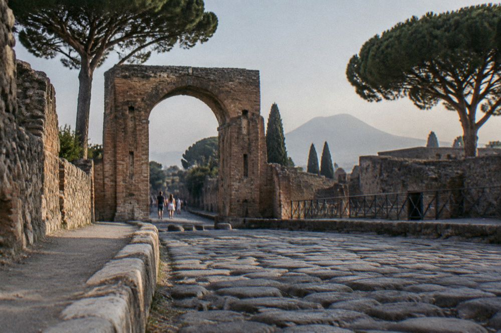 Guide and small group standing among Pompeian ruins listening to an explanation