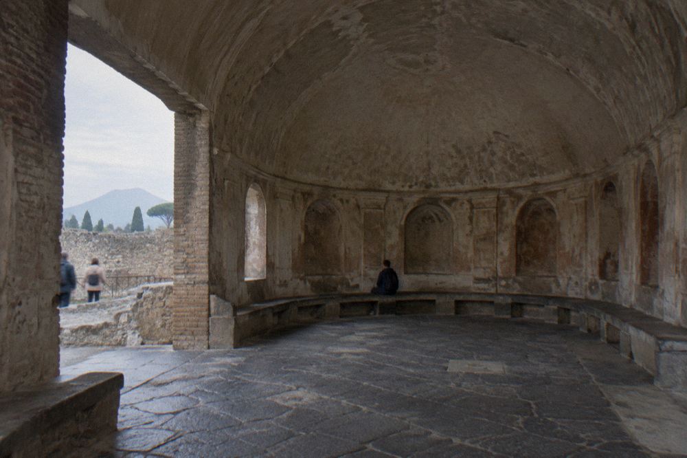 Columned ruins of the Pompeii Forum with Mount Vesuvius rising in the background