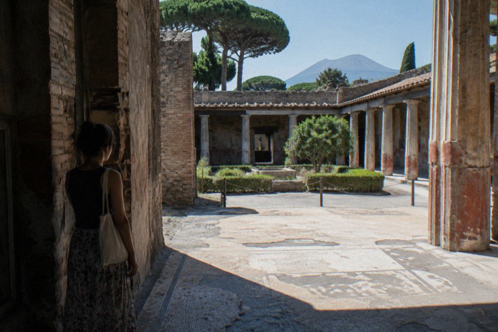 Grass-covered arena of the ancient amphitheatre at Pompeii surrounded by tiered stone seating