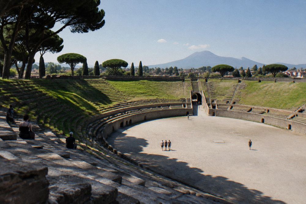 Water bottle and sun hat resting on a stone ledge beside an ancient Pompeii street