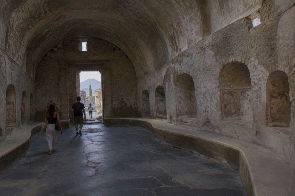 View across the excavated ruins of Pompeii toward the dome of Vesuvius on the horizon