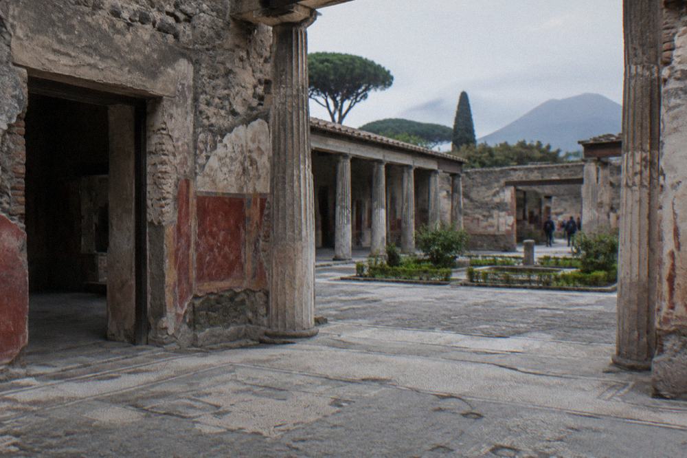 Excavated stone walls and shaded walkways of Herculaneum below the modern town